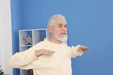 Photo of Elderly man exercising at home. Healthy leisure