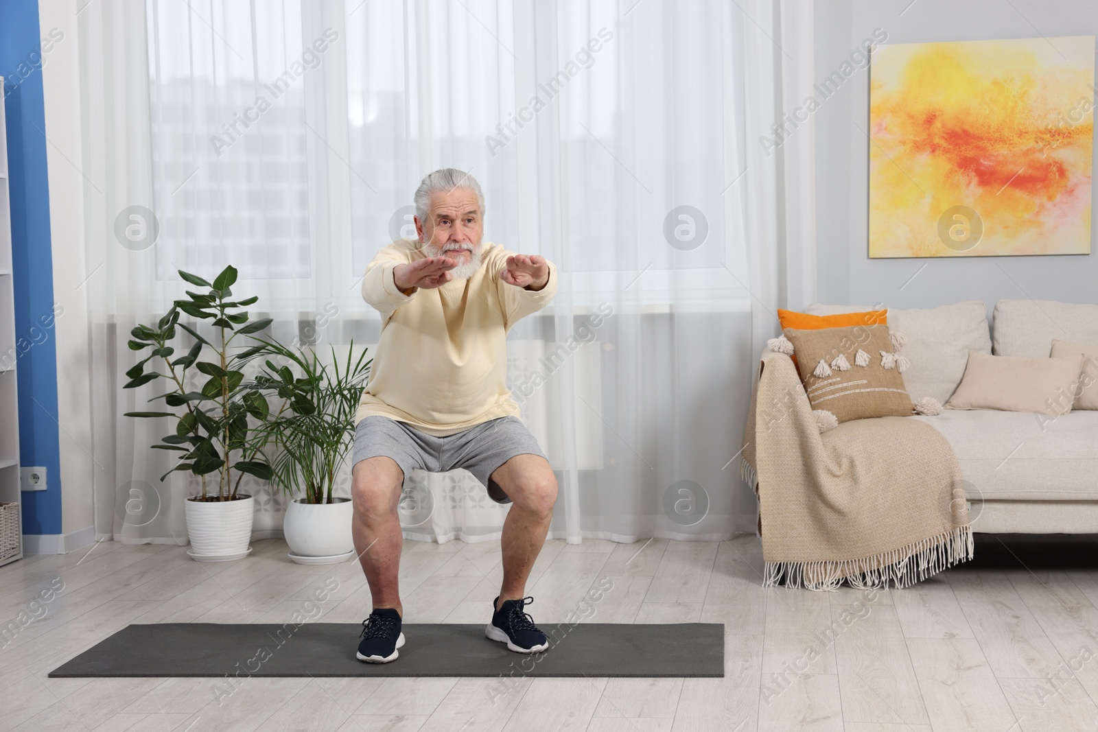 Photo of Elderly man exercising at home. Healthy leisure