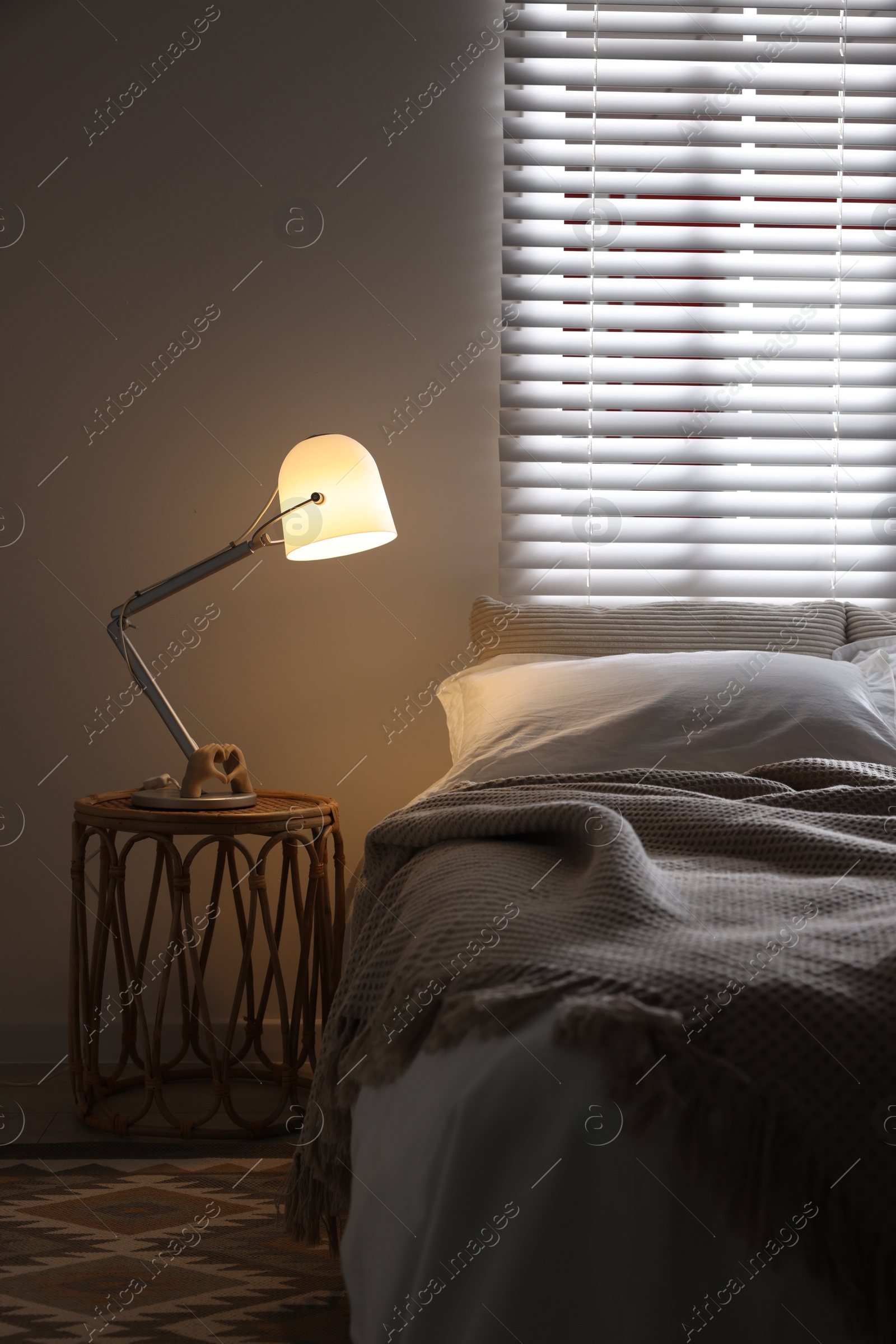 Photo of Glowing night lamp on bedside table indoors