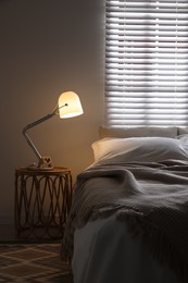 Photo of Glowing night lamp on bedside table indoors