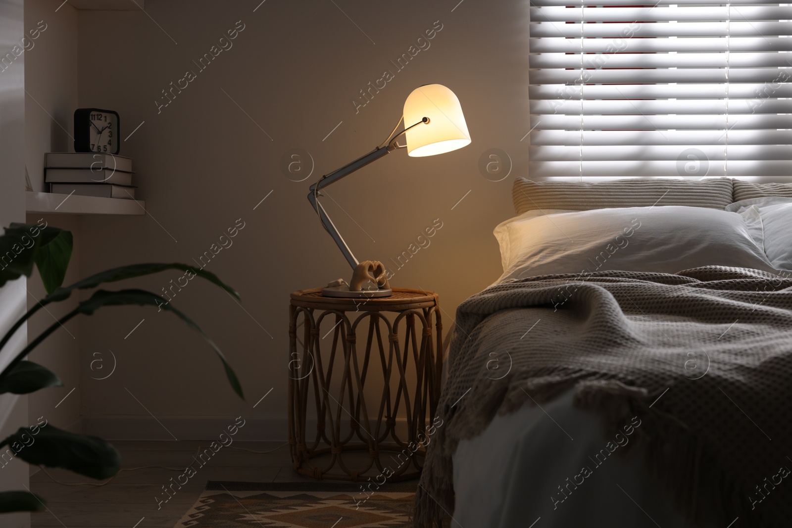 Photo of Glowing night lamp on bedside table indoors