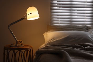 Photo of Glowing night lamp on bedside table indoors