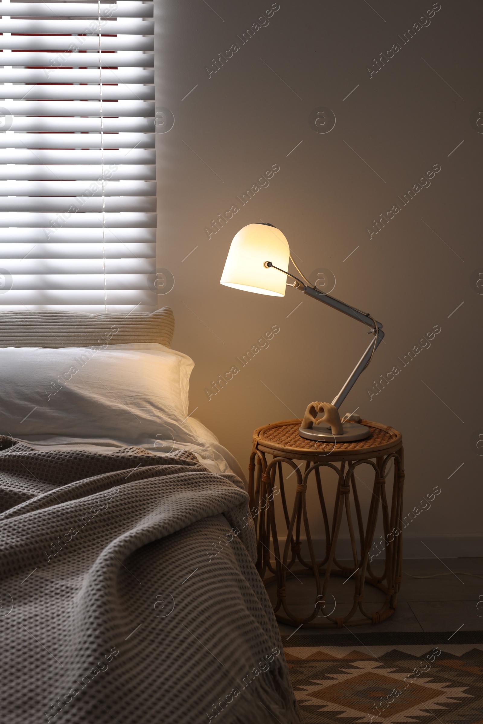 Photo of Glowing night lamp on bedside table indoors