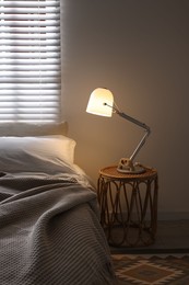 Photo of Glowing night lamp on bedside table indoors