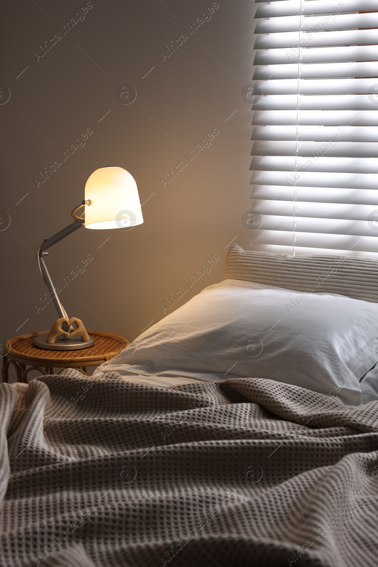 Photo of Glowing night lamp on bedside table indoors