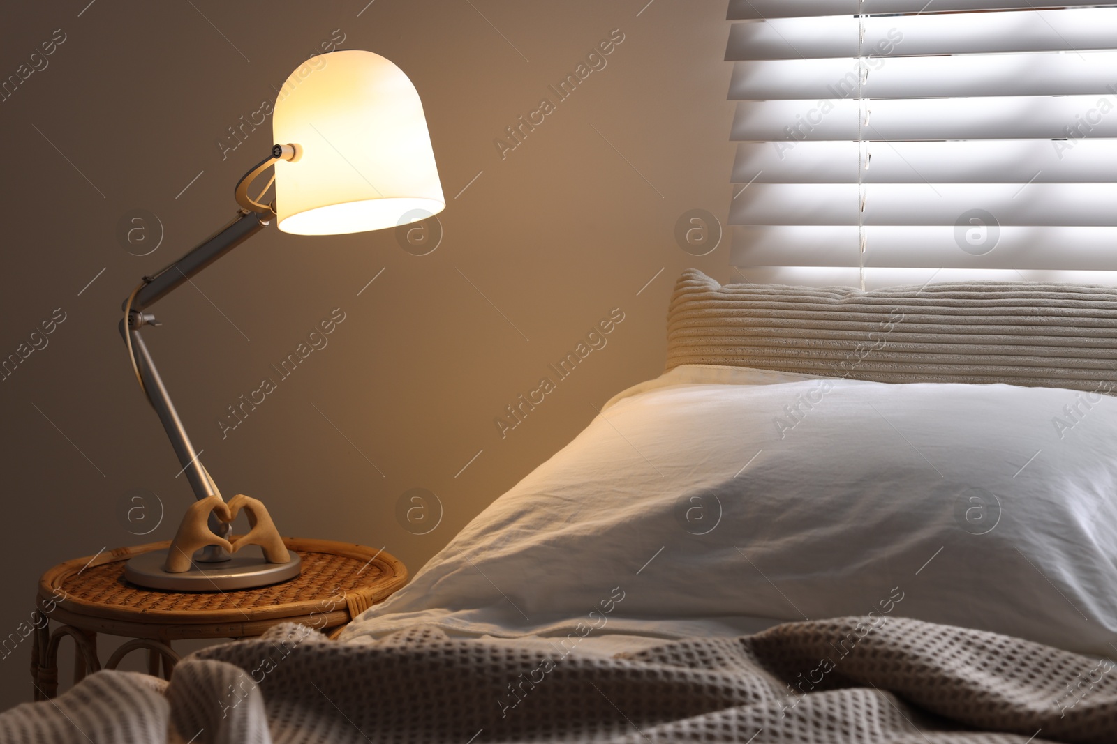 Photo of Glowing night lamp on bedside table indoors