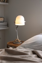 Photo of Glowing night lamp on bedside table indoors