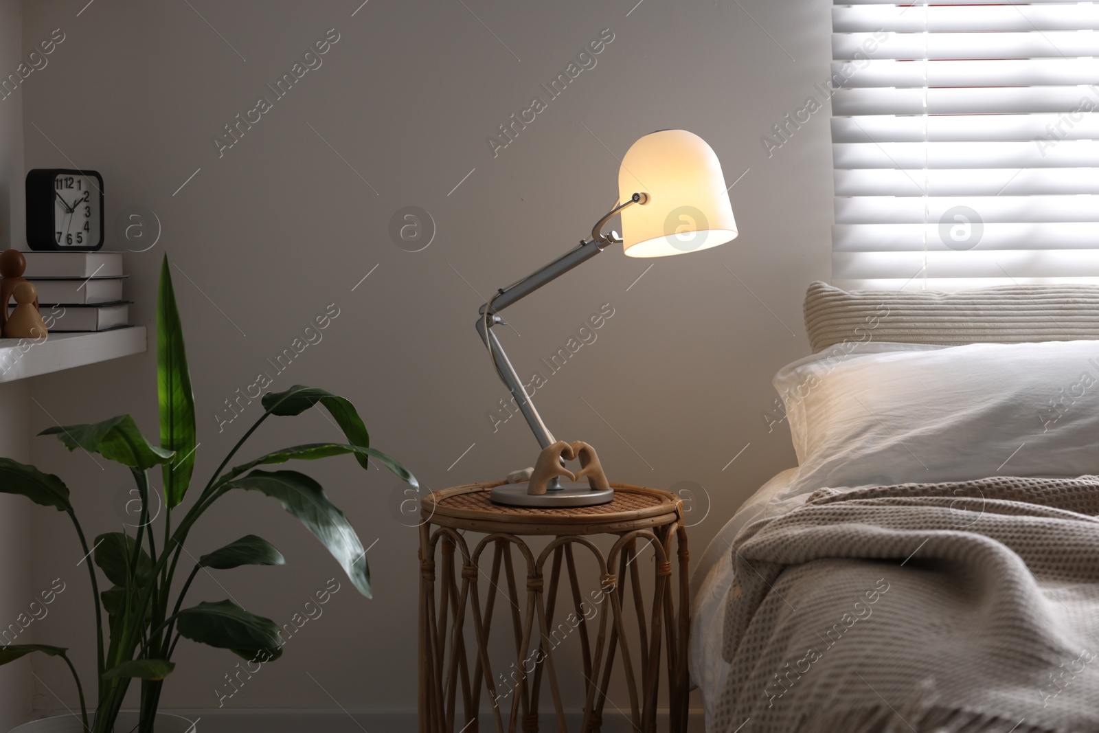 Photo of Glowing night lamp on bedside table indoors