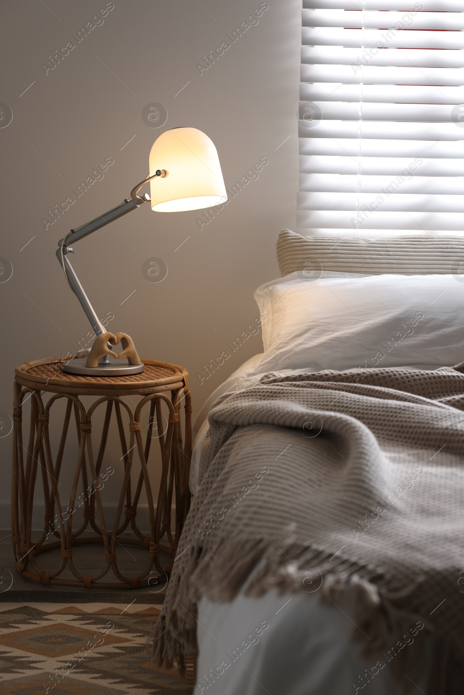 Photo of Glowing night lamp on bedside table indoors