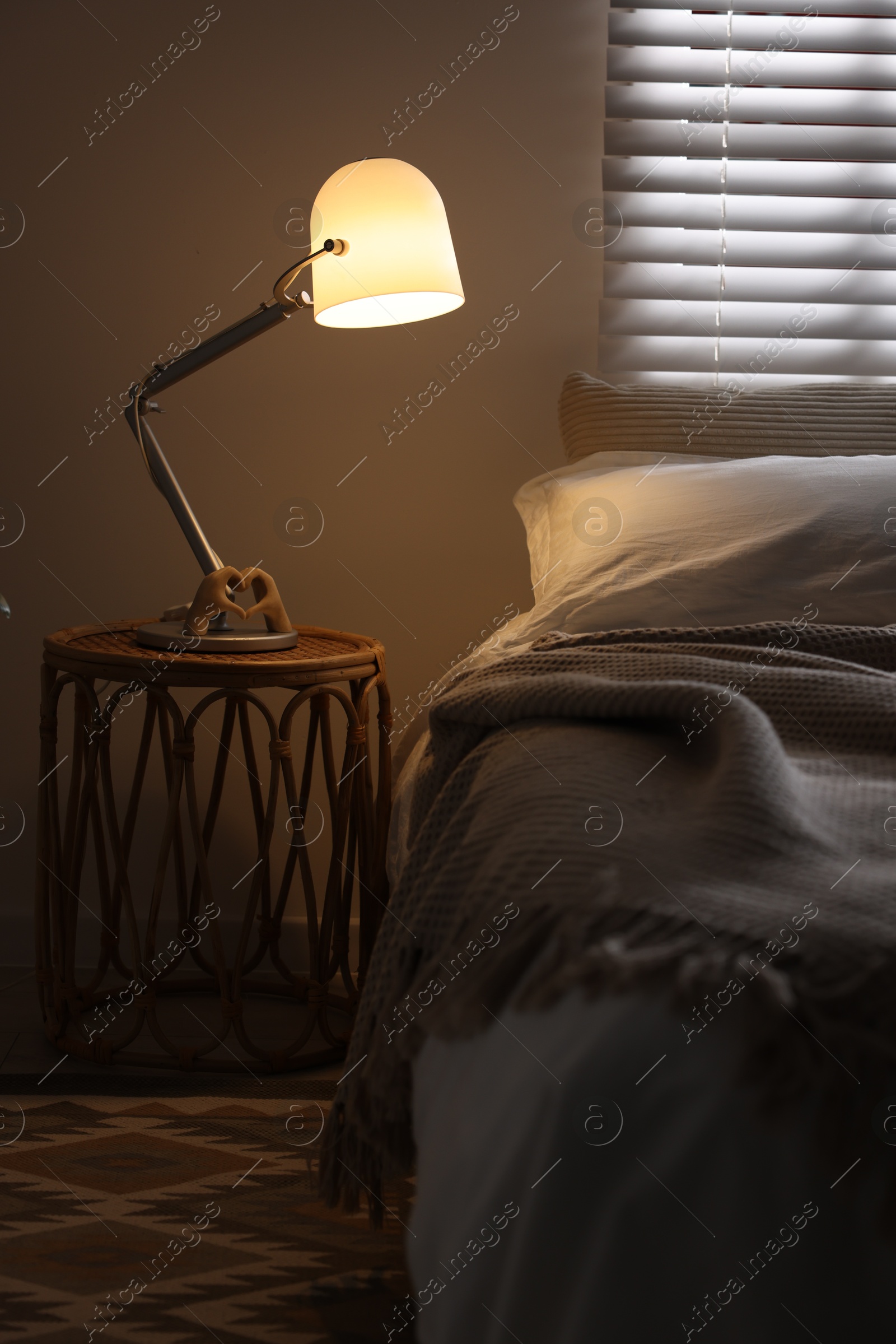 Photo of Glowing night lamp on bedside table indoors