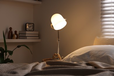 Photo of Glowing night lamp on bedside table indoors