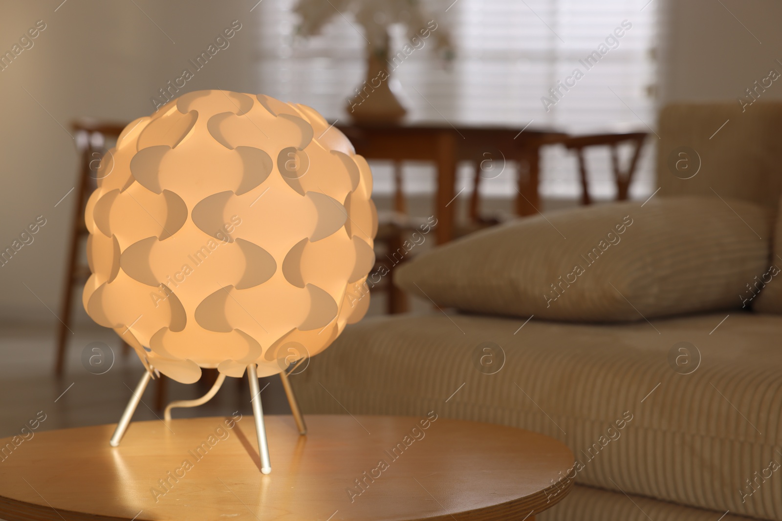 Photo of Glowing night lamp on wooden table at home