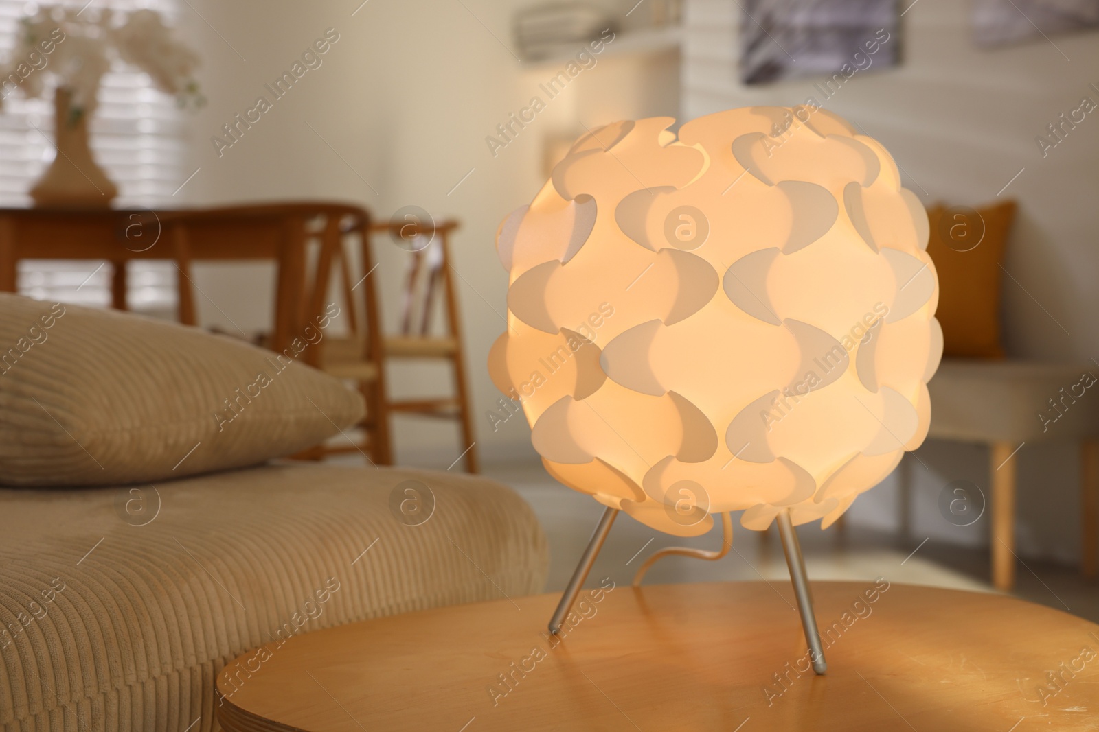 Photo of Glowing night lamp on wooden table at home