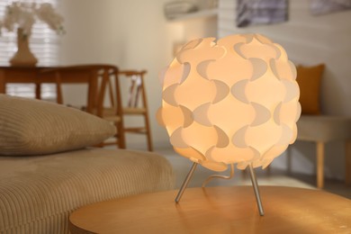 Photo of Glowing night lamp on wooden table at home