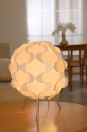 Photo of Glowing night lamp on wooden table at home