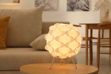 Photo of Glowing night lamp on wooden table at home