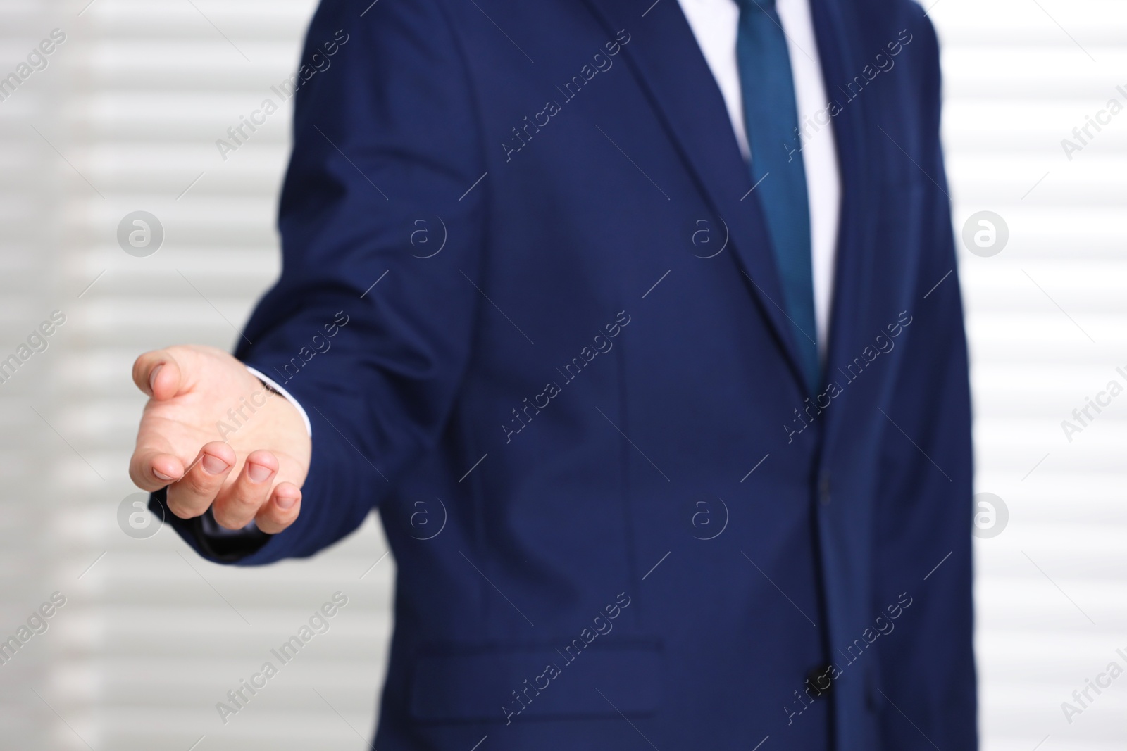 Photo of Man offering helping hand on light background, closeup