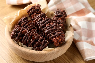 Photo of Delicious chocolate puffed rice bars on wooden table, closeup