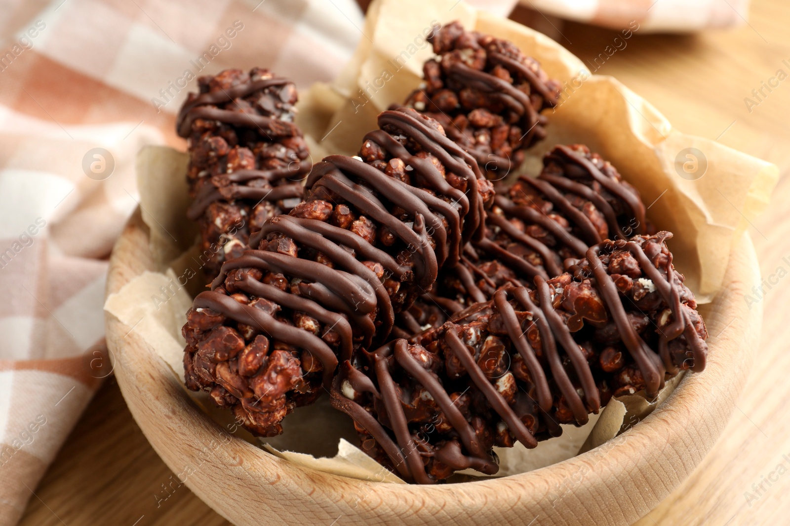 Photo of Delicious chocolate puffed rice bars on wooden table, closeup