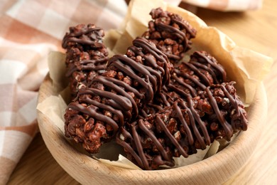 Photo of Delicious chocolate puffed rice bars on wooden table, closeup