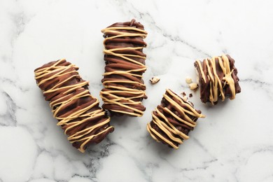 Photo of Delicious chocolate puffed rice bars on white marble table, flat lay