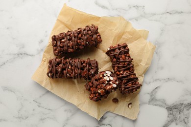 Photo of Delicious chocolate puffed rice bars on white marble table, top view