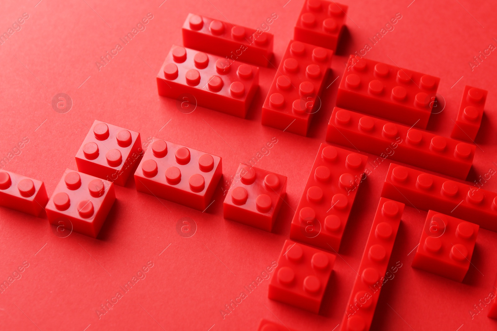 Photo of Construction toy. Building bricks on red background, closeup