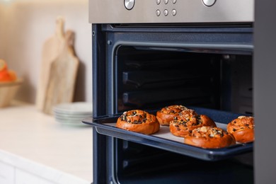 Photo of Baking pan with sweet buns in oven indoors, space for text