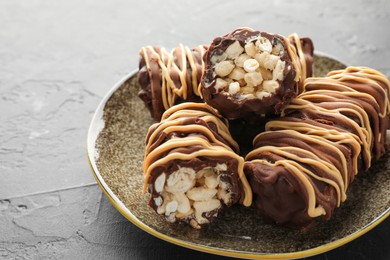 Photo of Delicious chocolate puffed rice bars on gray textured table, closeup