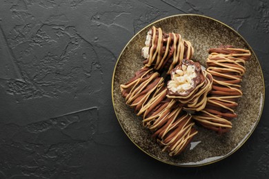 Photo of Delicious chocolate puffed rice bars on dark gray textured table, top view. Space for text