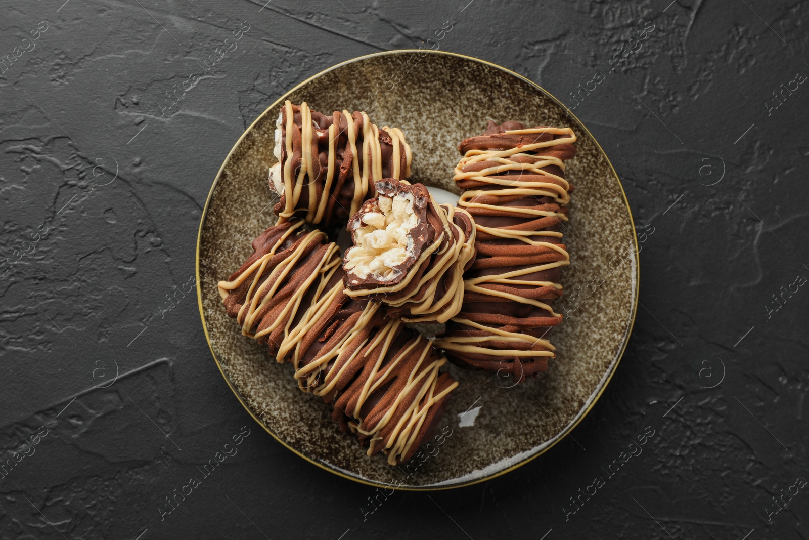 Photo of Delicious chocolate puffed rice bars on dark gray textured table, top view