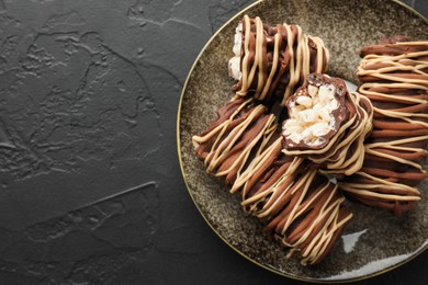 Photo of Delicious chocolate puffed rice bars on dark gray textured table, top view. Space for text