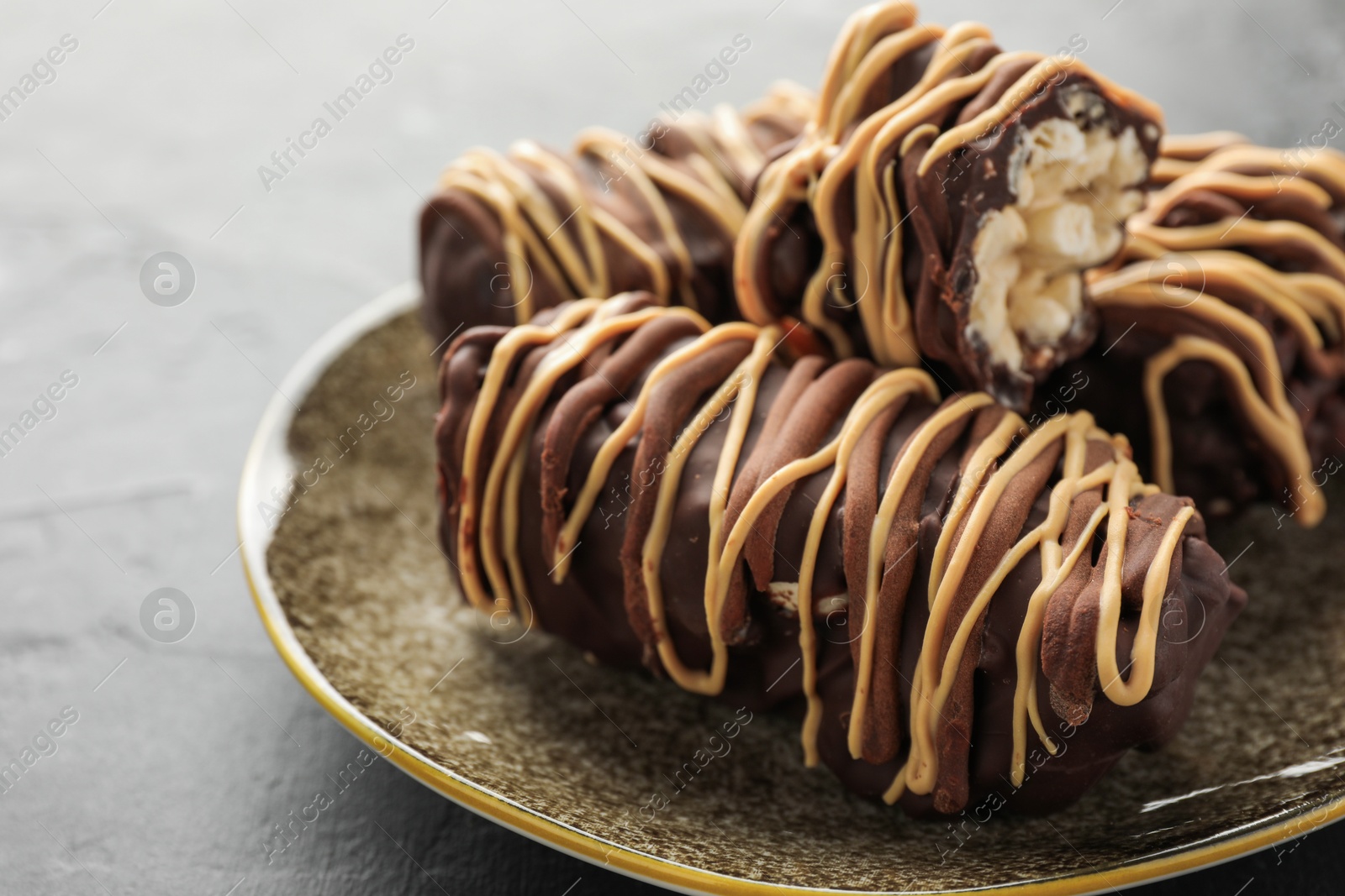 Photo of Delicious chocolate puffed rice bars on gray textured table, closeup