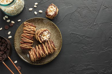 Photo of Delicious chocolate puffed rice bars and ingredients on dark gray textured table, flat lay. Space for text