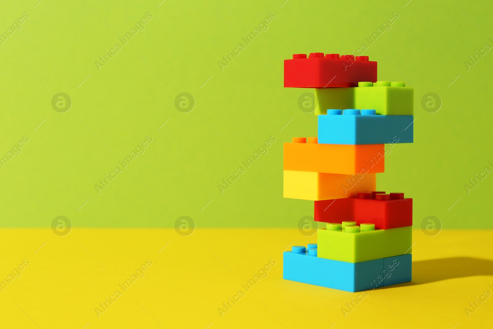 Photo of Construction toy. Figure made with building bricks on color background, space for text