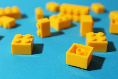 Photo of Construction toy. Bright building bricks on light blue background, closeup