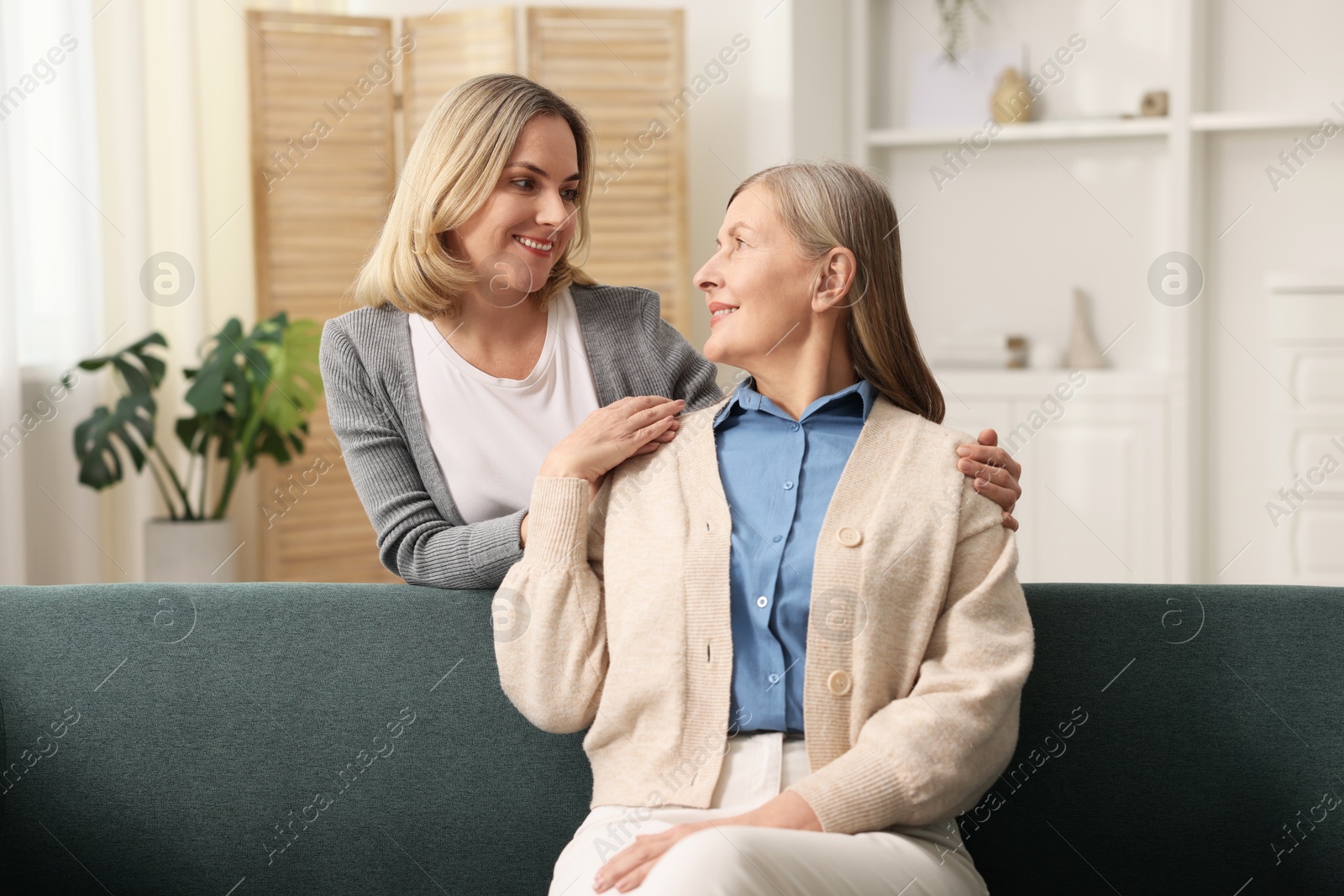 Photo of Smiling daughter and her mother at home