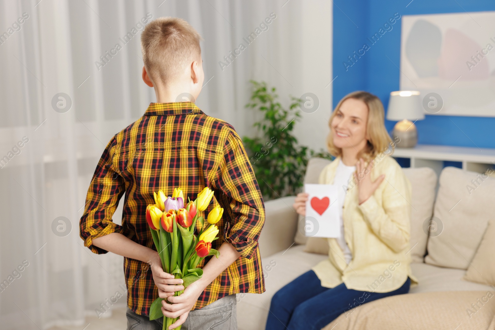 Photo of Happy Mother's Day. Son greeting his mom with flowers and card at home, selective focus