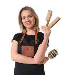 Photo of Smiling hairdresser with combs and brush on white background