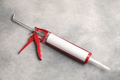 One glue gun on grey background. Construction tool