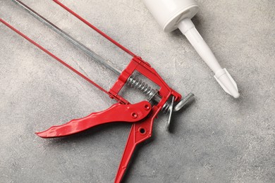 Photo of Glue gun and tube on grey background, closeup