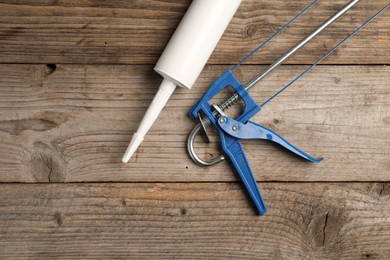 Photo of One glue gun on wooden background. Construction tool