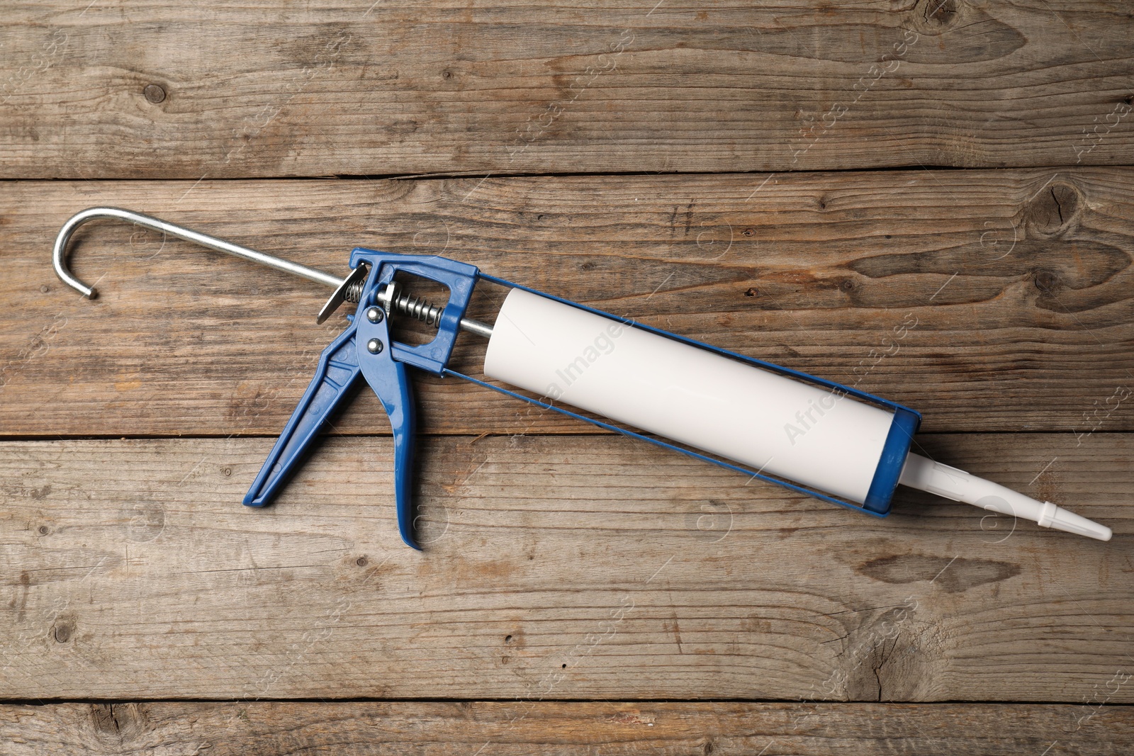 Photo of One glue gun on wooden background. Construction tool