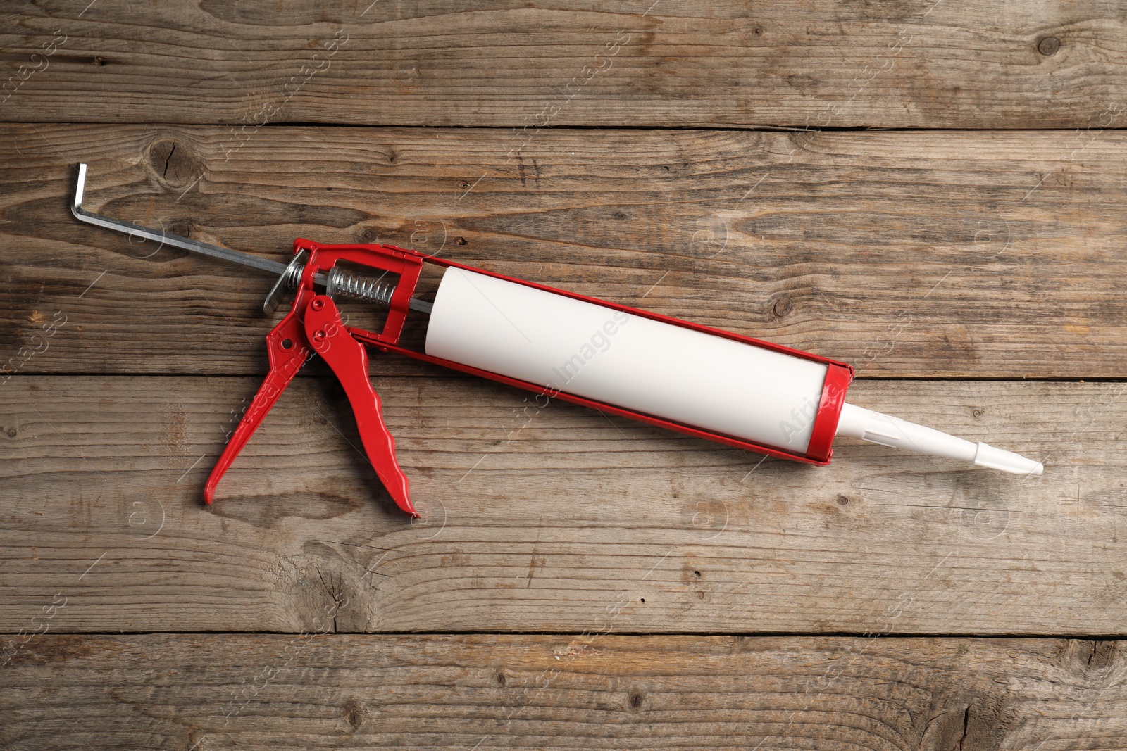 Photo of One glue gun on wooden background. Construction tool