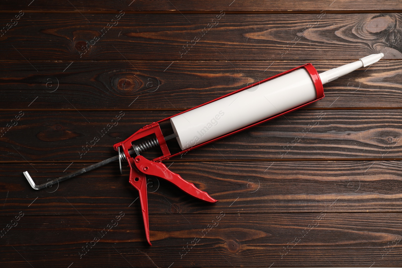 Photo of One glue gun on wooden background. Construction tool