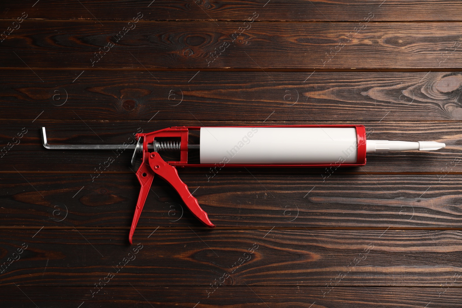 Photo of One glue gun on wooden background. Construction tool