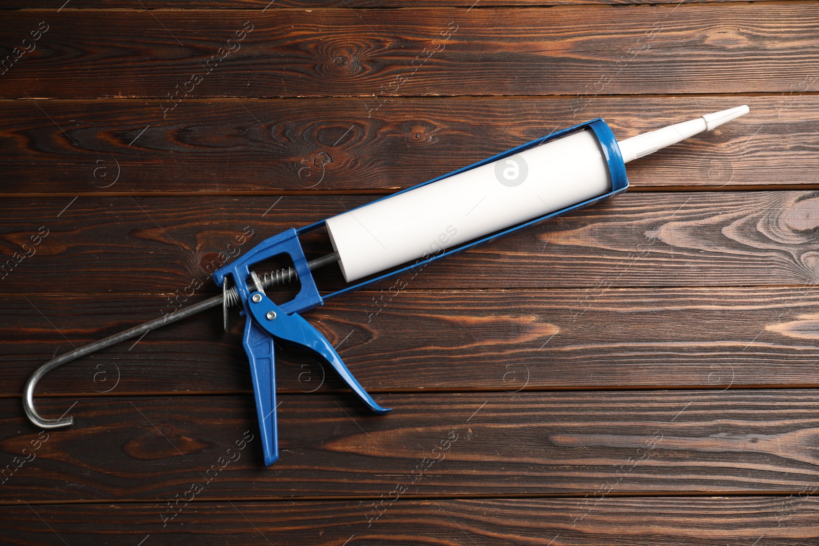 Photo of One glue gun on wooden background. Construction tool