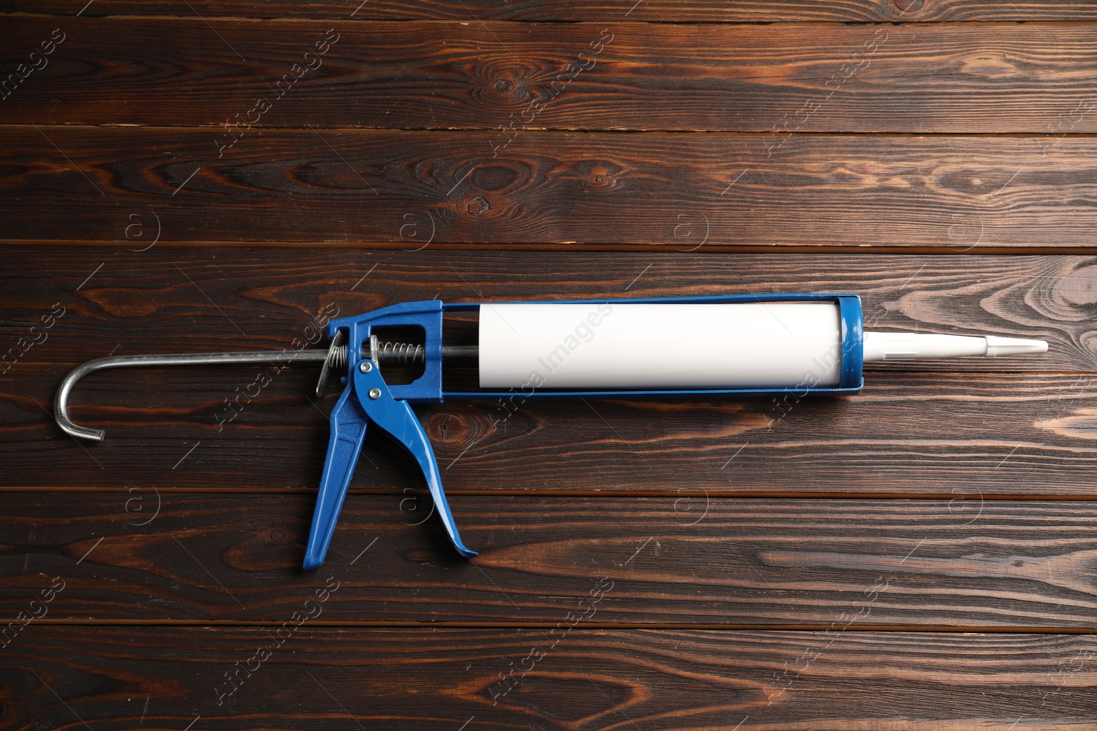 Photo of One glue gun on wooden background. Construction tool