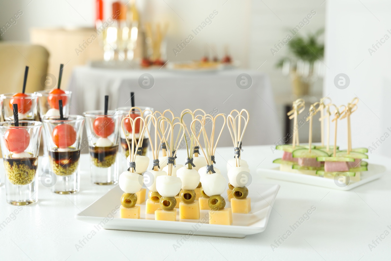 Photo of Many different tasty canapes on white table indoors