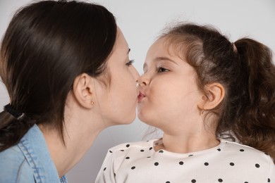 Photo of Cute little girl kissing her sister on white background